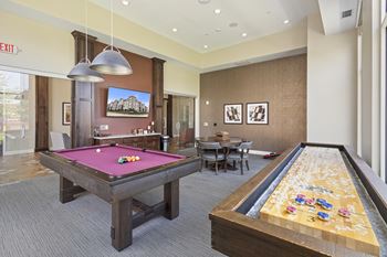 A game room with two pool tables and a billiard table